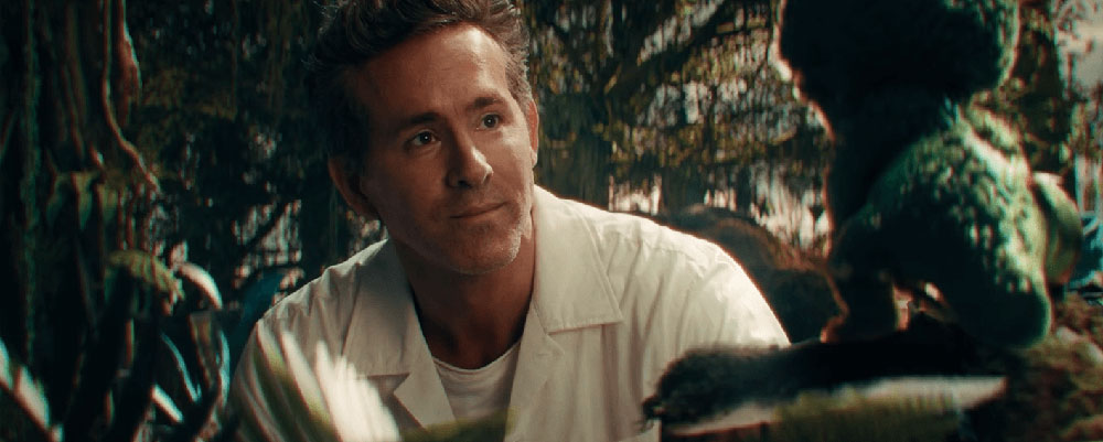 Close-up of Ryan Reynolds interacting with a small, animated character onscreen